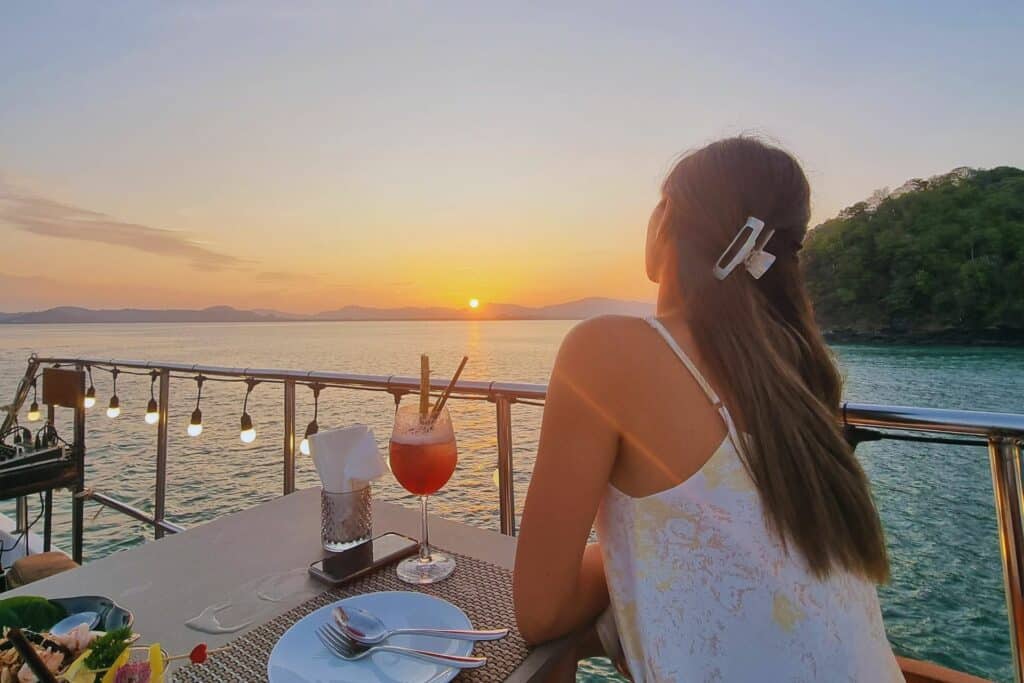 A woman facing the sunset on a cruise in Phuket solo travel